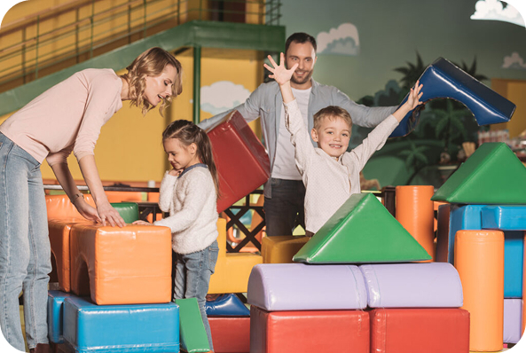Familienaktivität mit weichen Spielbausteinen in einer Indoor-Spielhalle